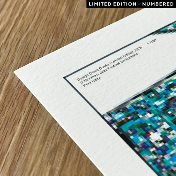 A close-up of the Poster David Bowie, 1995, Limited Edition art print with a pixelated design, placed on a wooden surface. The text highlights the Montreux Jazz Festival Switzerland and David Bowie Limited Edition 2023.