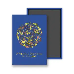 Un carnet bleu intitulé "Magnet Albin Christen, 2000" présente un cercle abstrait coloré et un texte jaune pour le 34e Festival de Jazz de Montreux, du 7 au 22 juillet 2000. Le carnet apparaît à côté d'une boîte ouverte.