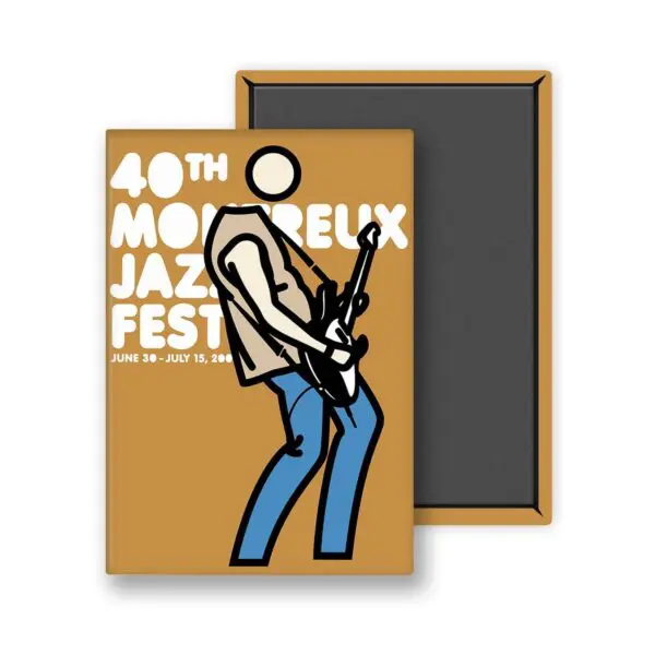 Un aimant rectangulaire appelé "Magnet Julian Opie, 2006 - Mustard", représente une personne sans visage de style Julian Opie avec une guitare et un texte blanc en gras : "40th Montreux Jazz Fest, June 30 - July 15, 2006" sur un fond brun moutarde.