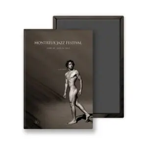 Le Magnet Greg Gorman, 2012, présente une image sépia d'un homme nu sur le sable avec la mention "LISTEN" au-dessus et les dates du Montreux Jazz Festival, du 29 juin au 14 juillet 2012, imprimées dans la partie supérieure.
