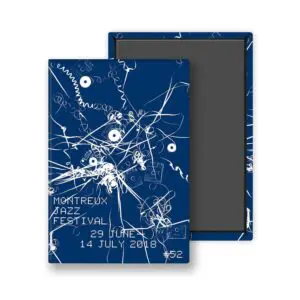 The Magnet Christian Marclay, 2018 présente des lignes de bandes audio et des contours de cassettes enchevêtrés en bleu et blanc, faisant écho au charme audio vintage. Inspirée par l'affiche du Montreux Jazz Festival 2018 de Marclay (#52), elle est présentée partiellement dans une boîte ouverte.