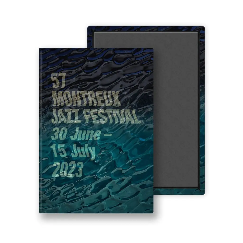 Aimant représentant l'œuvre de Guillaume "SupaKitch" Grando pour la 57e édition du Montreux Jazz Festival, avec les dates de l'événement (30 juin - 15 juillet 2023) sur un motif d'eau ondulée.