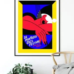Poster Marylou Faure, 2021 displays abstract red arms, hands, guitar, and bold black, blue, yellow, and white tones with handwritten event details. The framed poster is shown hanging above a chair and plant.