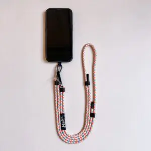 A smartphone with a Mobile Strap, Lakeside lanyard featuring vibrant orange, white, and blue colors with a metal clip, laid flat on a light surface.