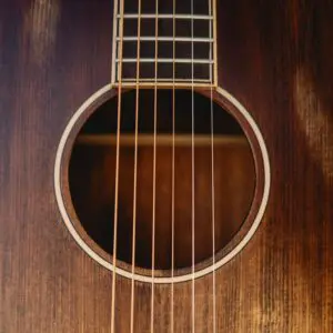 Close-up of the Miami Electro Acoustic Guitar Limited Series' sound hole and strings, displaying the wood grain and circular opening in the body, with six strings stretched vertically across the image.