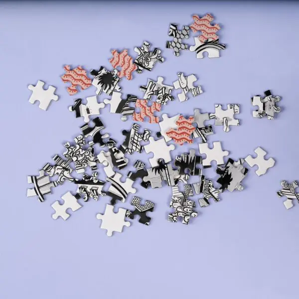 A heap of 1000 Piece Rylsee Puzzle pieces from the Montreux Jazz collection lies on a light purple surface, showing black, white, and red patterns with wavy red lines, black shapes, and partial illustrations.