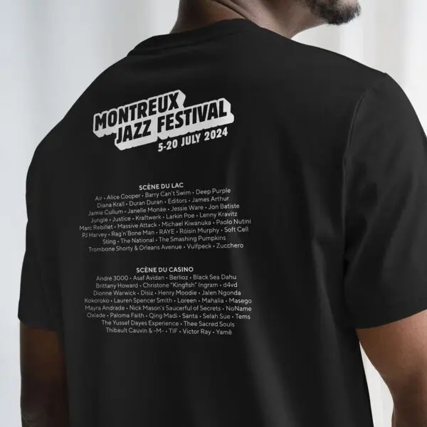 A person wearing a black T-Shirt Lineup 2024, Limited Edition, featuring Montreux Jazz Festival dates and a list of Scène du Lac and Scène du Casino artists, all printed in white on the back.