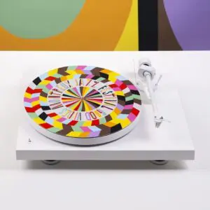 The Slipmat Vinyl Lakwena is a white turntable slipmat with a colorful geometric pattern and the words "Montreux Jazz Festival Good Vibes," set against a vibrant, abstract background.