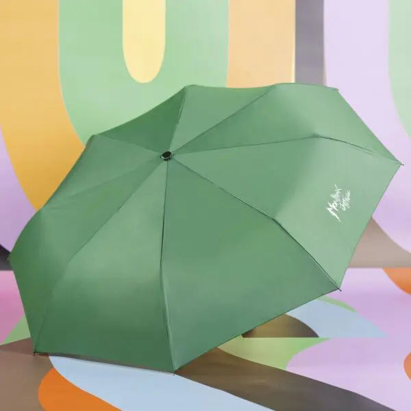 Un parapluie Parapluie vert avec un texte en blanc est ouvert et placé sur un fond abstrait et coloré avec des formes courbes en orange, vert, jaune et violet.