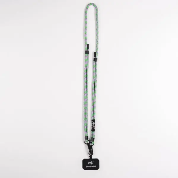 The Mobile Strap, Lakeside is a long, braided lanyard in green, purple, and gray, with black clips and a black tag with white text—designed as a stylish mobile accessory inspired by the Montreux Festival, shown on a plain white background.